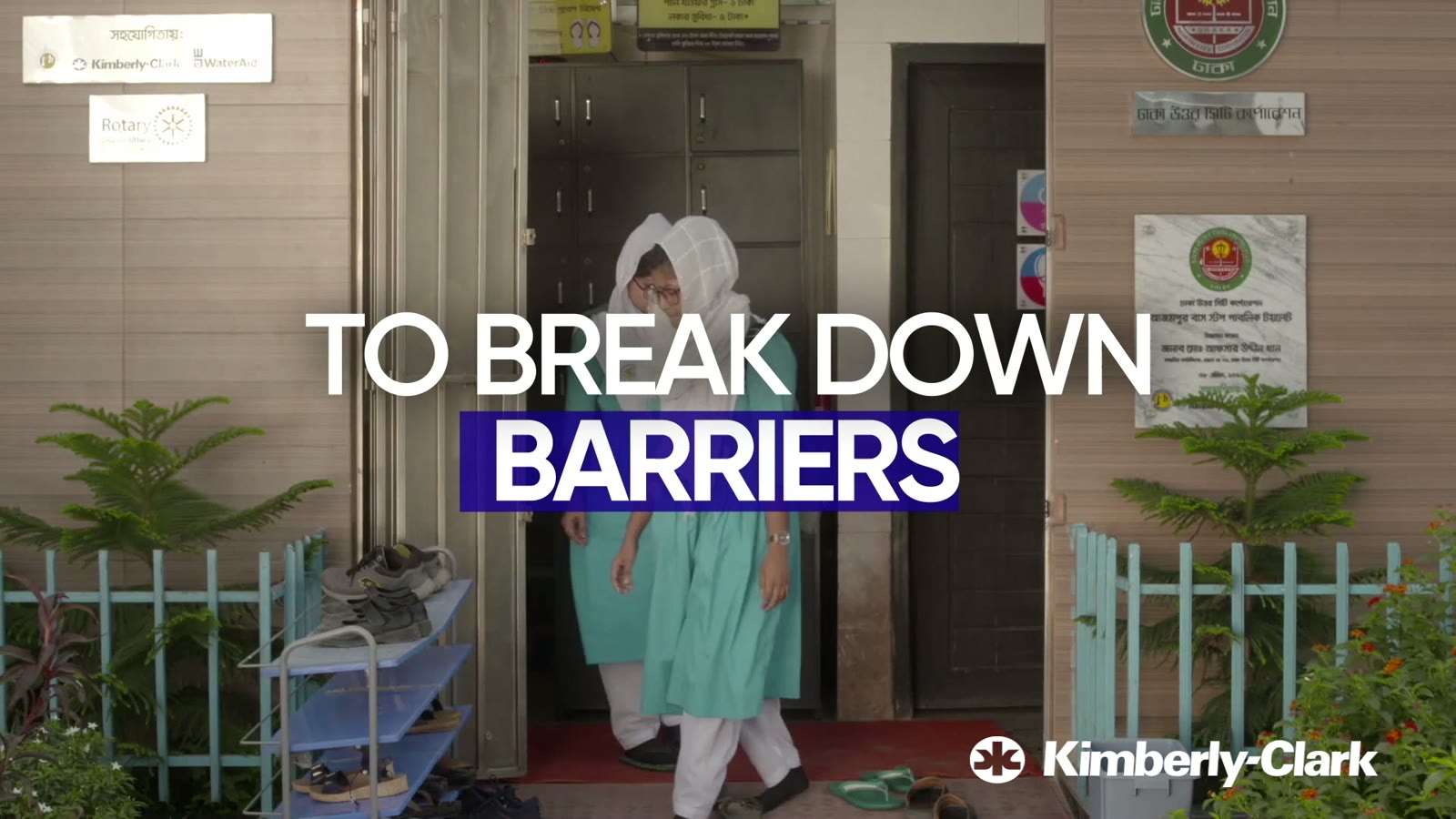 A girl in a school uniform in a doorway, with the words To break down barriers