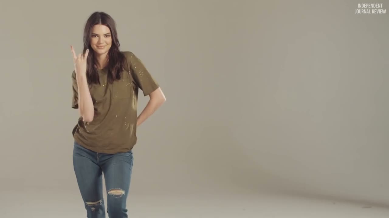 Kendall in a grunge tee throwing a rock sign