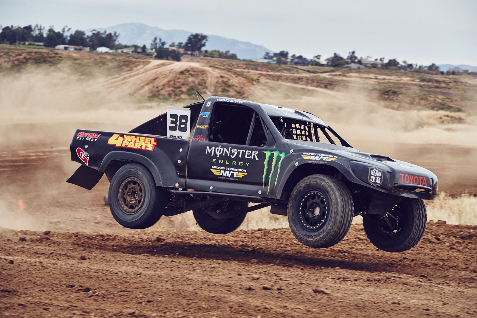 Hailie Deegan's off-road race truck kicking up dirt on a dirt track